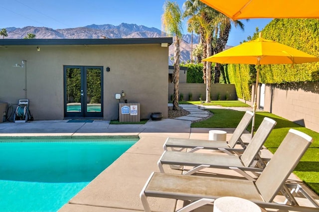 view of swimming pool featuring french doors, a mountain view, and a patio