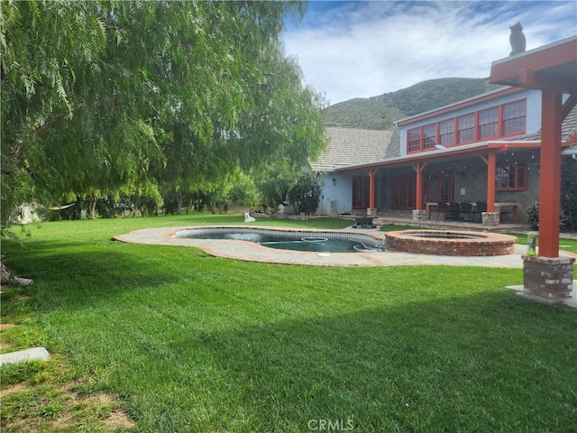 exterior space featuring an in ground hot tub and a lawn