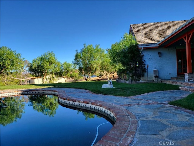 view of swimming pool with a yard