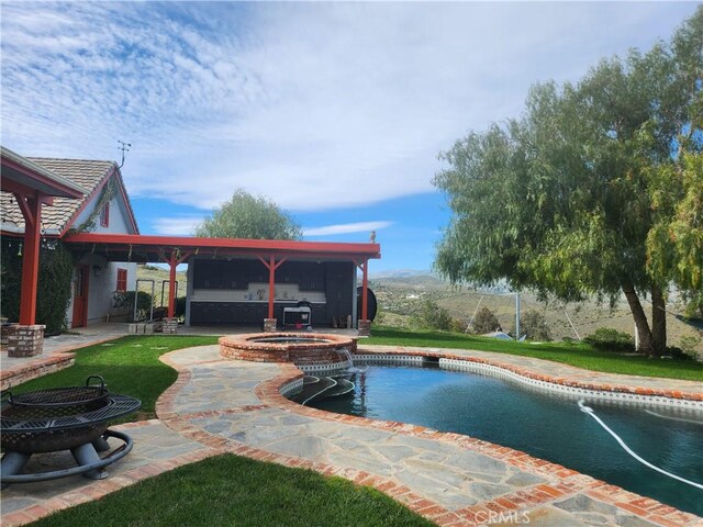 view of pool with a patio, a fire pit, and an in ground hot tub