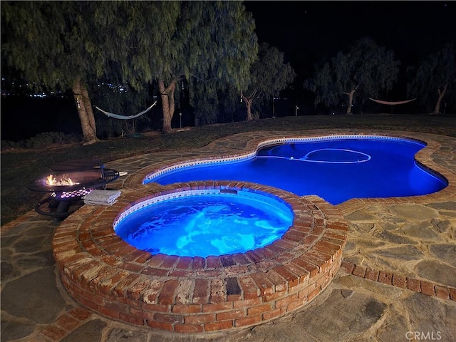 view of swimming pool featuring an in ground hot tub and a patio