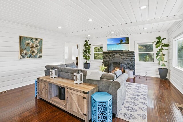 living room featuring dark wood-type flooring and a stone fireplace