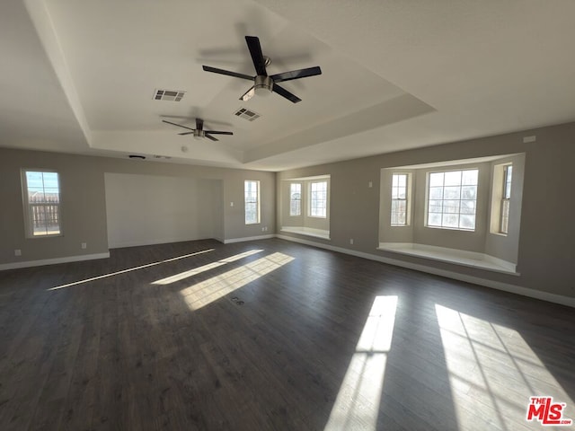 unfurnished room featuring ceiling fan, dark hardwood / wood-style flooring, and a raised ceiling