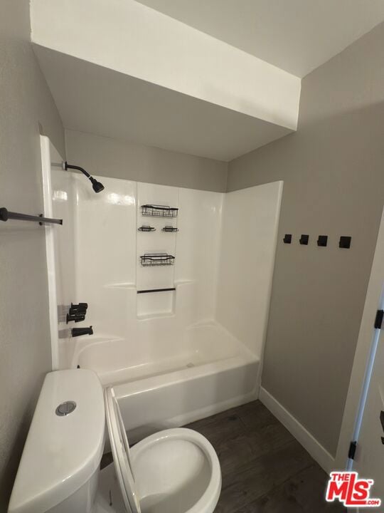 bathroom with toilet and bathing tub / shower combination