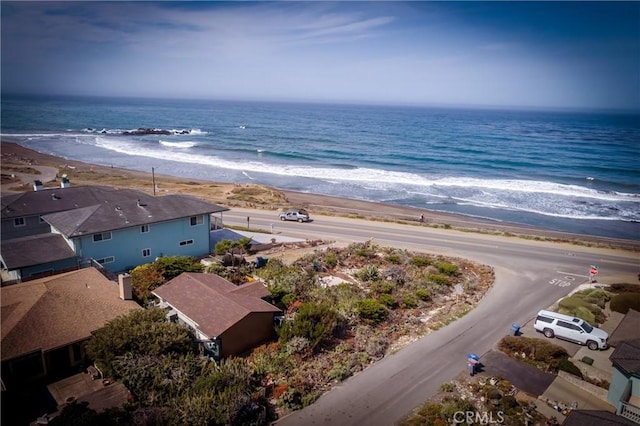 birds eye view of property featuring a water view and a beach view