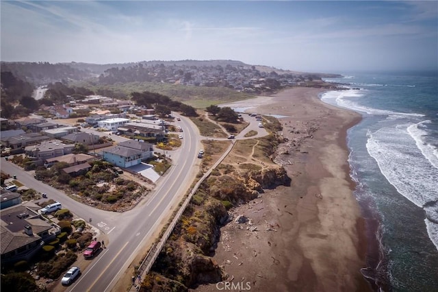 drone / aerial view featuring a beach view and a water view