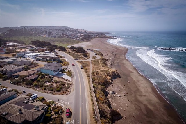 birds eye view of property with a water view and a beach view