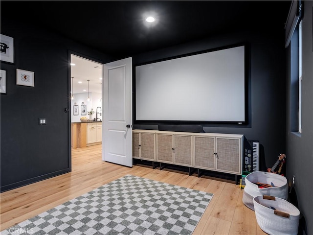 cinema room with light hardwood / wood-style flooring