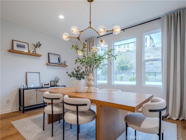 dining room with light hardwood / wood-style floors and a chandelier