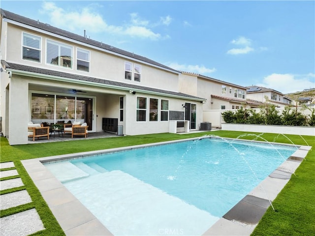 view of pool featuring pool water feature, a yard, an outdoor hangout area, and central AC unit