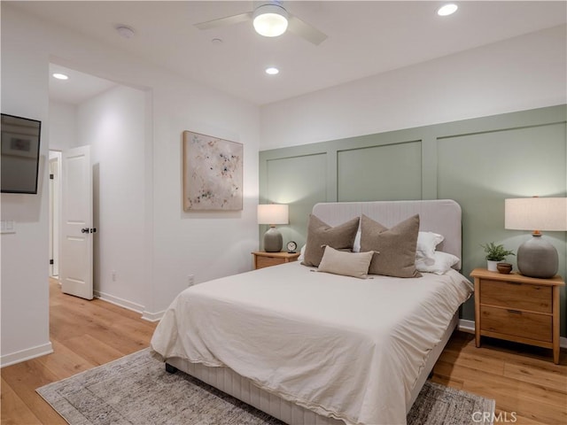 bedroom featuring two closets, ceiling fan, and light hardwood / wood-style floors