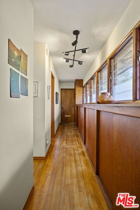 hall with light hardwood / wood-style flooring and a notable chandelier