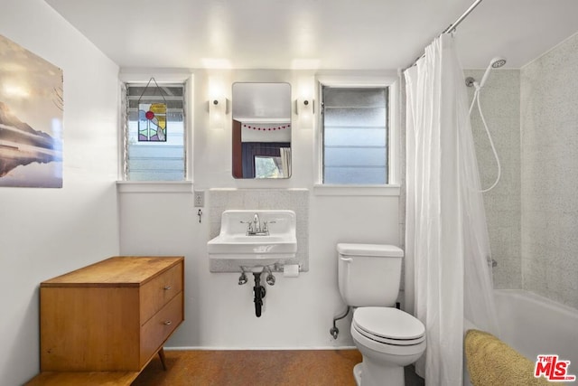 full bathroom with shower / bath combo with shower curtain, sink, and toilet