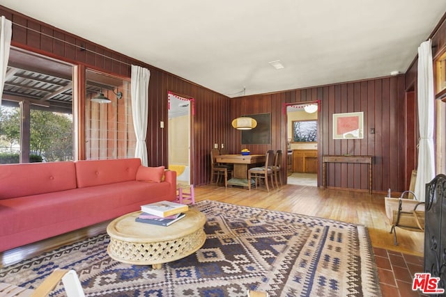 living room with wood-type flooring and wooden walls