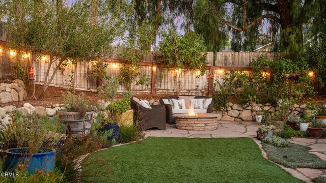 view of yard with a patio area and an outdoor living space with a fire pit