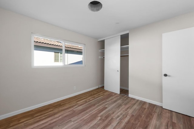 unfurnished bedroom with a closet and wood-type flooring