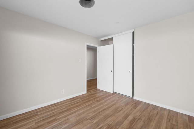 unfurnished bedroom with a closet and light wood-type flooring