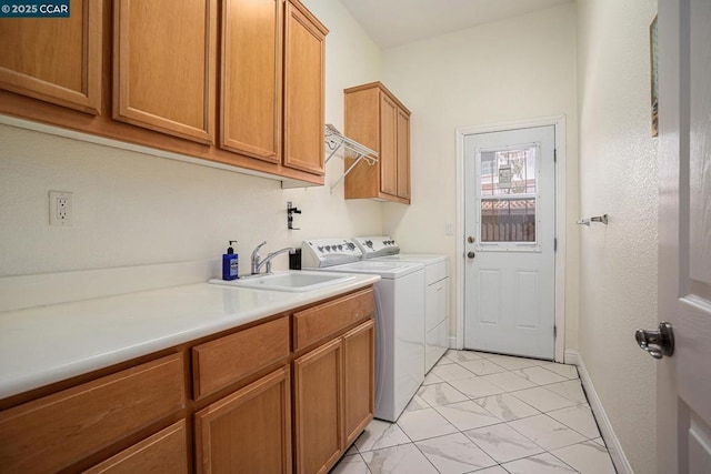 clothes washing area featuring cabinets, separate washer and dryer, and sink