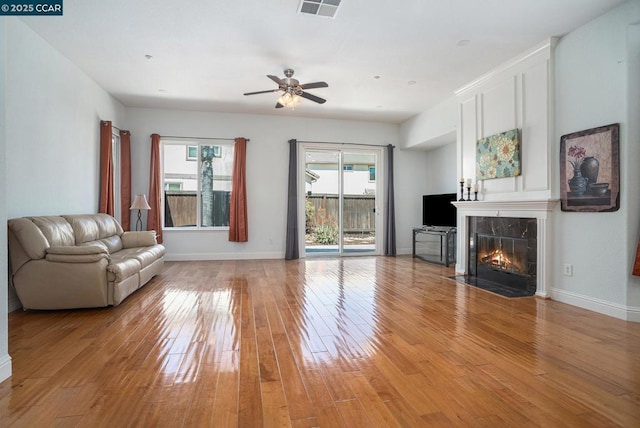 unfurnished living room with ceiling fan, light hardwood / wood-style floors, and a fireplace