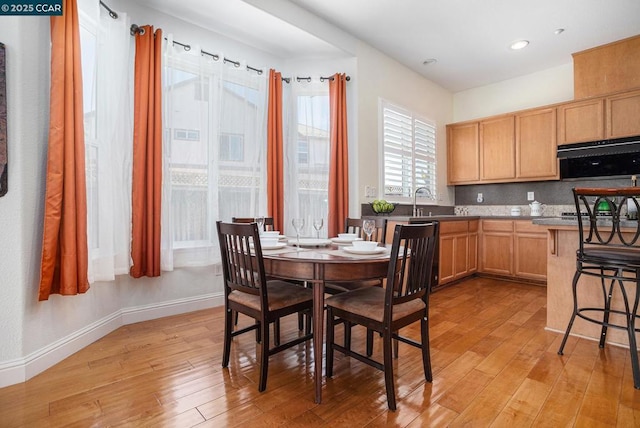 kitchen with decorative backsplash, light hardwood / wood-style floors, and sink