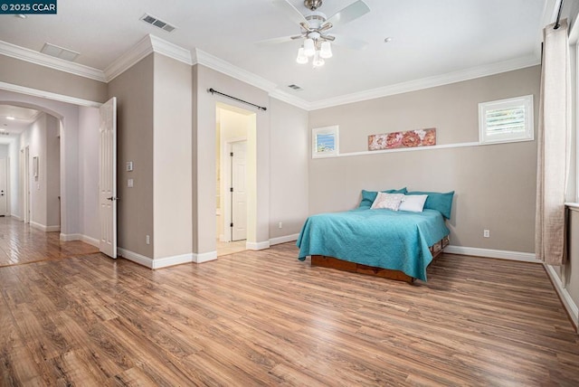 bedroom featuring ceiling fan, wood-type flooring, and crown molding