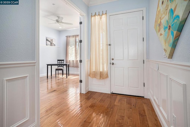 corridor featuring light hardwood / wood-style flooring and crown molding