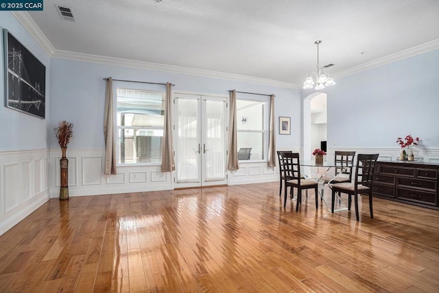 dining room featuring a notable chandelier, crown molding, and hardwood / wood-style flooring