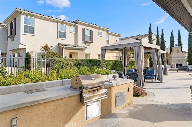 view of patio / terrace with exterior fireplace, a grill, area for grilling, and a gazebo