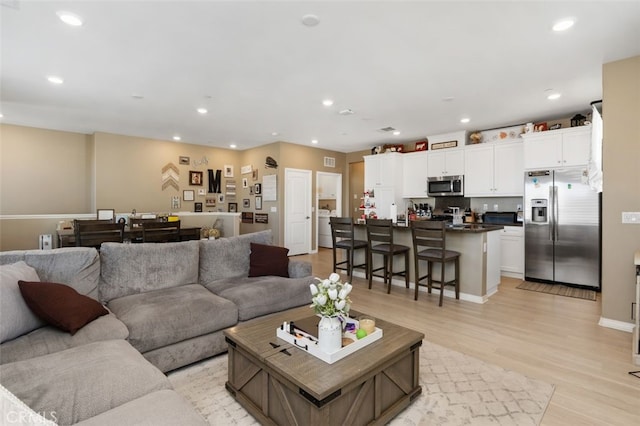 living room featuring light wood-type flooring and washer / clothes dryer