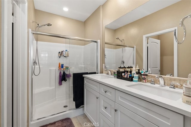 bathroom featuring a shower with door and vanity