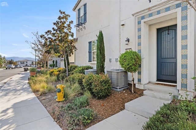 property entrance with a mountain view and cooling unit