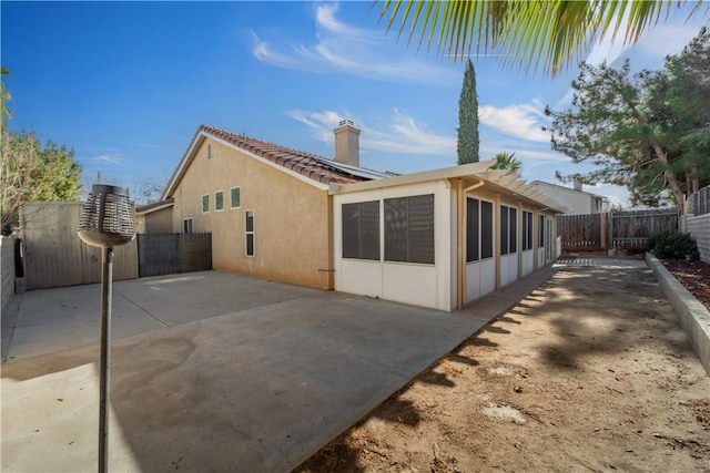 rear view of house with a sunroom and a patio