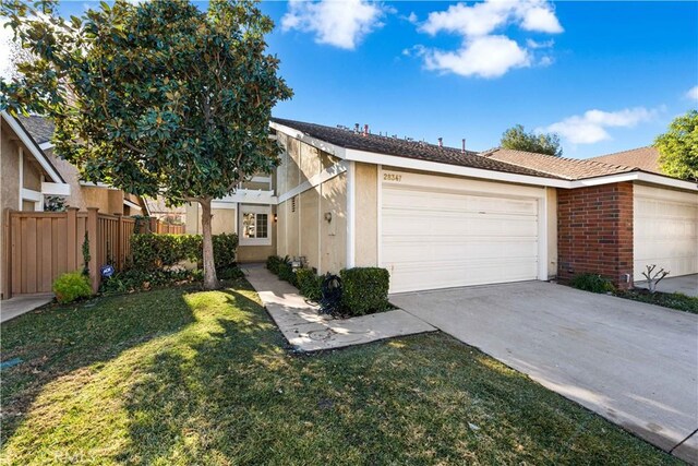 ranch-style home featuring a front yard and a garage