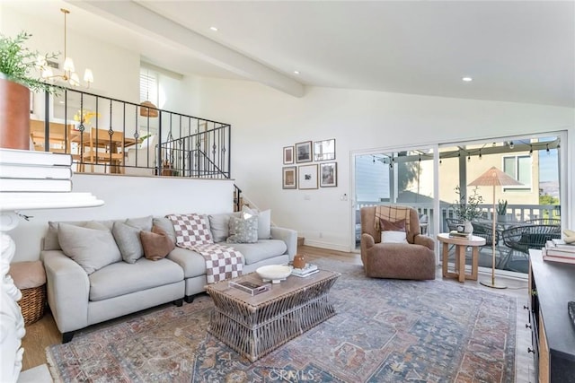 living room featuring hardwood / wood-style flooring, a chandelier, and lofted ceiling with beams