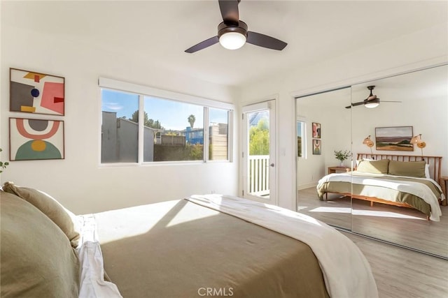 bedroom featuring access to exterior, wood-type flooring, a closet, and ceiling fan