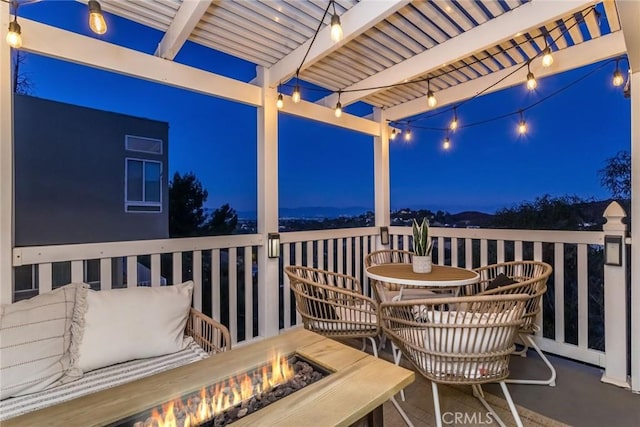 deck at night with a pergola and a fire pit