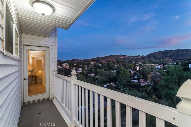 balcony at dusk featuring a mountain view