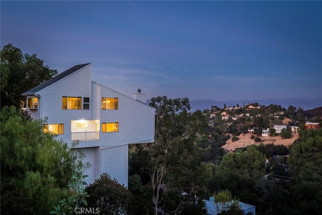 property exterior at dusk featuring a balcony