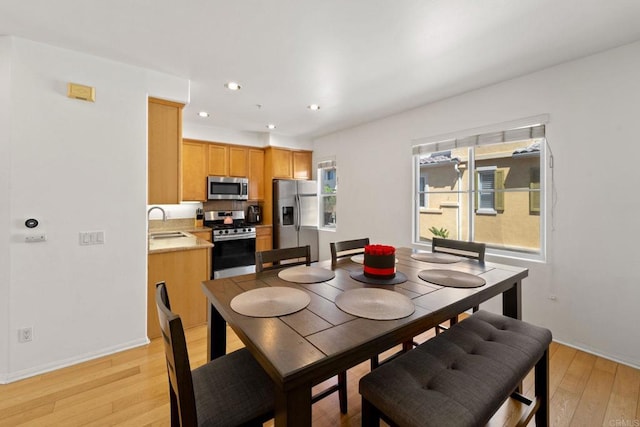 dining space with sink and light hardwood / wood-style flooring