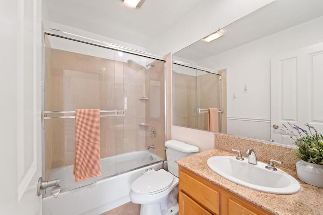 full bathroom featuring toilet, bath / shower combo with glass door, tile patterned flooring, and vanity