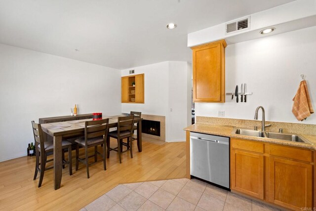 kitchen featuring light wood-type flooring, dishwasher, and sink