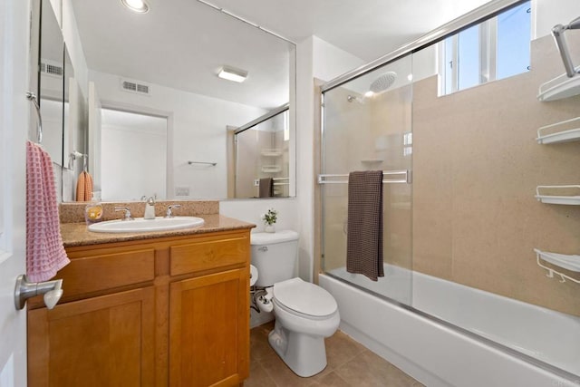 full bathroom with tile patterned floors, shower / bath combination with glass door, vanity, and toilet