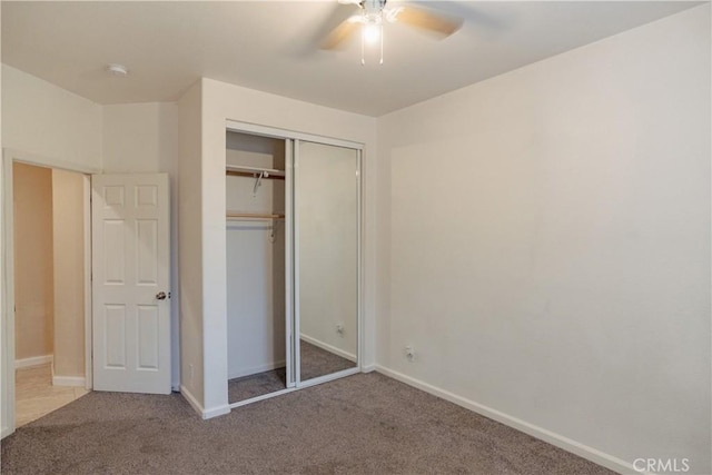 unfurnished bedroom with ceiling fan, carpet floors, and a closet