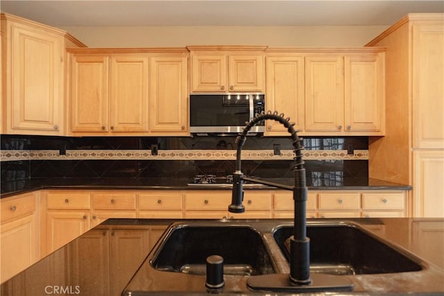 kitchen featuring tasteful backsplash, light brown cabinetry, and sink