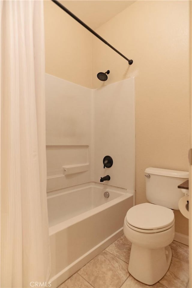 bathroom with tile patterned flooring, tub / shower combination, and toilet