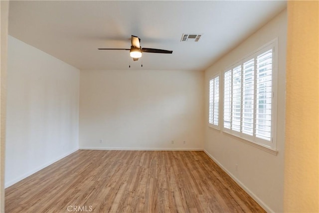 empty room with ceiling fan and light hardwood / wood-style floors