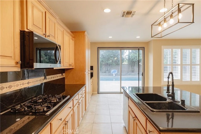 kitchen with pendant lighting, sink, gas stovetop, a healthy amount of sunlight, and light brown cabinets