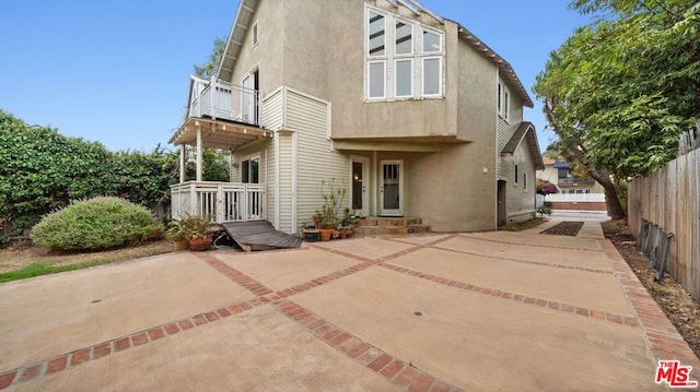 rear view of property featuring a patio area and a balcony