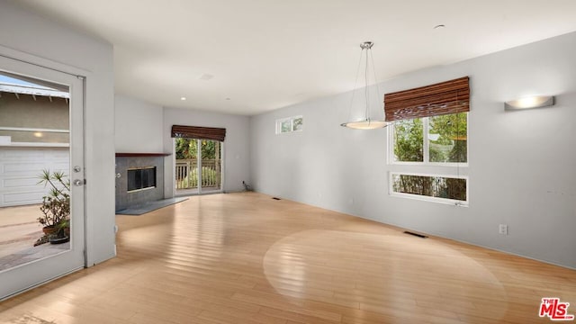 unfurnished living room featuring a fireplace and light hardwood / wood-style floors