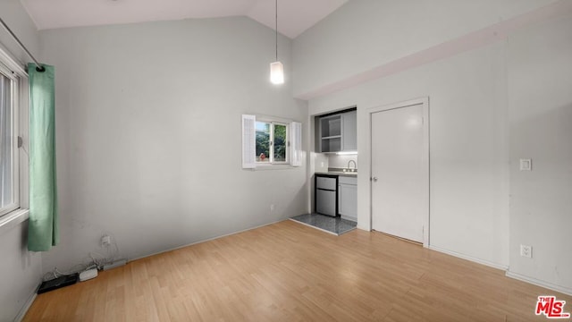 interior space with sink, light hardwood / wood-style flooring, and lofted ceiling